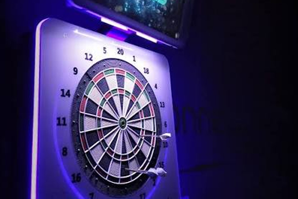 Máquina de dardos electrónica con iluminación LED instalada en un bar de Estepa.